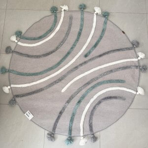 tapis rond pour enfant couleur gris , avec des méches en relief et des pompons